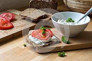 curd cheese dip with herbs and rustic wholegrain bread with tomatoes