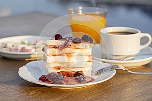 Curd cheese with red cherry jam, orange juice and cup coffee on table. Breakfast concept