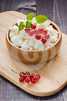 curd cheese with red currant in a wooden plate/curd cheese with