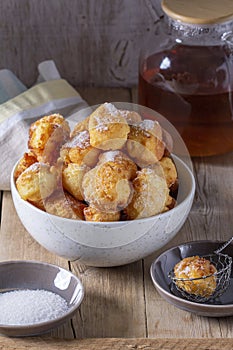 Curd donuts with sugar served with tea or coffee on a light wooden background. Rustic style.