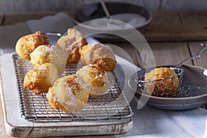 Curd donuts with sugar served with tea or coffee on a light wooden background. Rustic style.