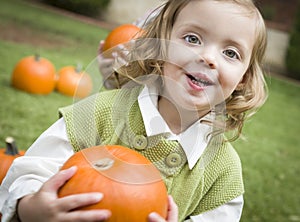 Cure Young Child Girl Enjoying the Pumpkin Patch.