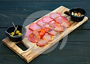 Cured meat platter. Chorizo, salami, ham, olives on a wooden board