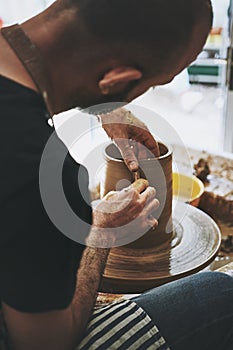 Curiosity is the key to creativity. an unrecognisable man working with clay in a pottery studio.