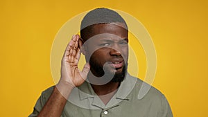 Curious African American Man Keeping Hand Near Ear, Trying To Overhear Information