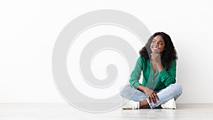 Curious african american woman looking at copy space on white