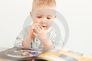 curious baby boy studying with the book