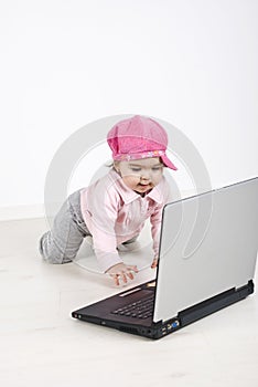 Curious baby crawling to laptop