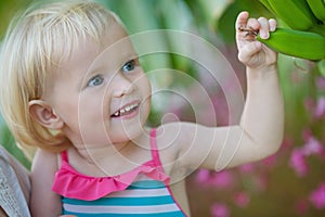 Curious baby exploring banana palm