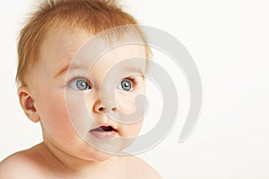 Curious baby with fuzzy hair and open mouth