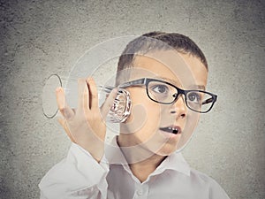 Curious boy listening with glass cup to a conversation