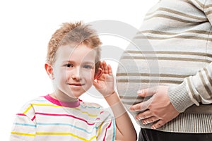 Curious boy listening his pregnant mother abdomen