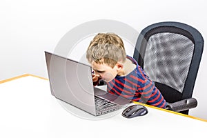 Curious Caucasian preschool boy using laptop, studio shot.