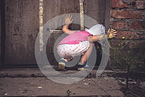 Curious child looking into dark hole in barn door in countryside shed concept curiosity