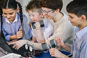 Happy children learn programming using laptops on extracurricular classes