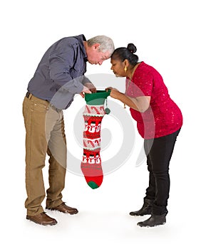 Curious couple looking in christmas stocking