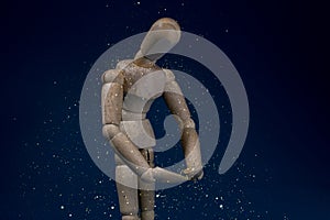 Curious downtrodden mannequin standing in gold rain photo