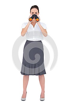 Curious elegant businesswoman holding binoculars