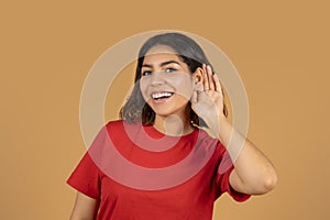 Curious excited young arabic woman touching her ear with hand