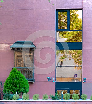 Curious facade in pink where new styles of windows are mixed with classic viewpoint or little terrace