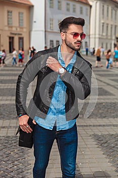 Curious fashion man with red sunglasses going sightseeing the city