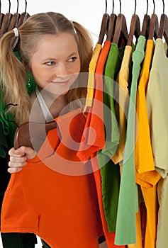 Curious girl looking out of the clothes rack