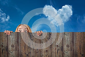 Curious hide woman / girl, cloud heart shape, blue sky background