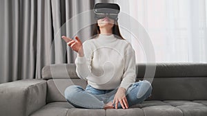 Curious housewife in VR goggles swipes virtual interface