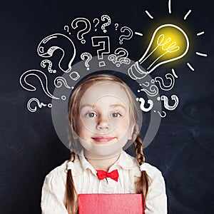 Curious kid of school age with lightbulb and chalk question mark photo