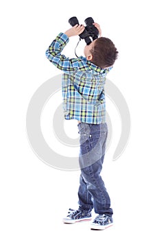 Curious little boy is looking left up through binoculars