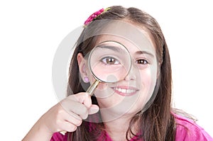 Curious little girl is looking through magnifying glass