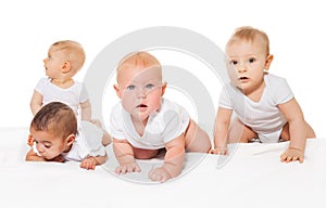 Curious looking babies crawl in a row together