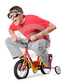 Curious man in goggles on a children's bicycle