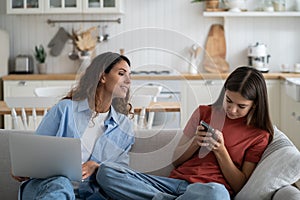 Curious European mother invades teenage daughter privacy by wanting to look at SMS on mobile phone photo
