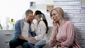 Curious mother-in-law secretly listening woman whispering secret on husband ear