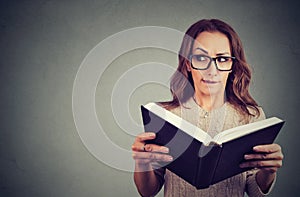 Curious nerd woman reading book