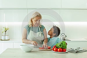 Curious nosy child with his mother indoors in kitchen