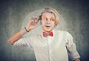 Curious nosy man with glass jar listening to a private conversation