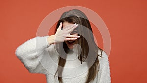 Curious nosy woman covering eyes with hand, peeking through fingers, prying