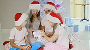 Curious parents and siblings opening a Christmas gift, the light comes from inside.