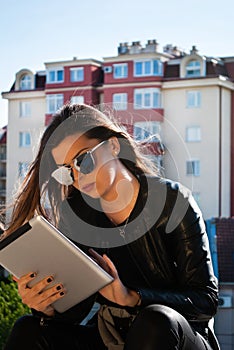 Curious and Stylish: Tech-Savvy Teenager Engrossed in Digital Exploration on a Tablet