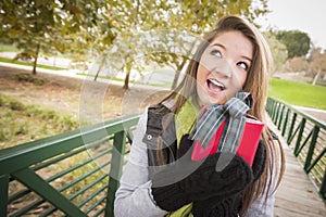 Curious Teen Shakes Wrapped Gift with Bow Outside