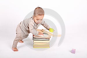 Curious toddler boy playing with books and wooden blocks