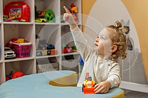 Curious Toddler Boy in Playroom Pointing Upward