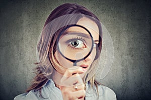 Curious woman looking through a magnifying glass