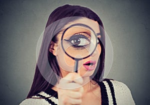 Curious woman looking through a magnifying glass