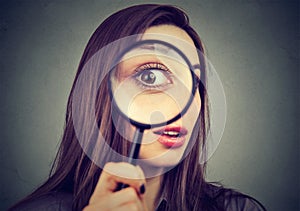 Curious woman looking through a magnifying glass