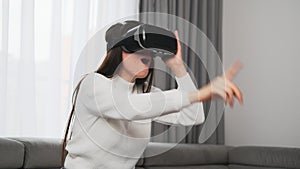 Curious woman looks through VR glasses turning to sides