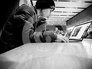 Curious young boy reading on Apple MacBook pro retina laptop