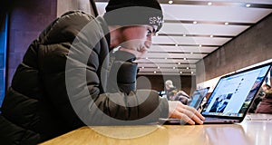 Curious young boy reading on Apple MacBook pro retina laptop